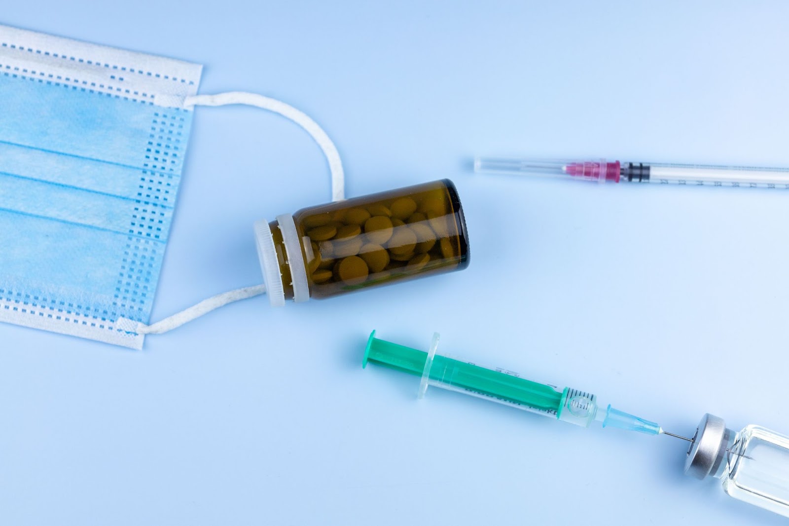 flatlay of syringes and bottle of supplements