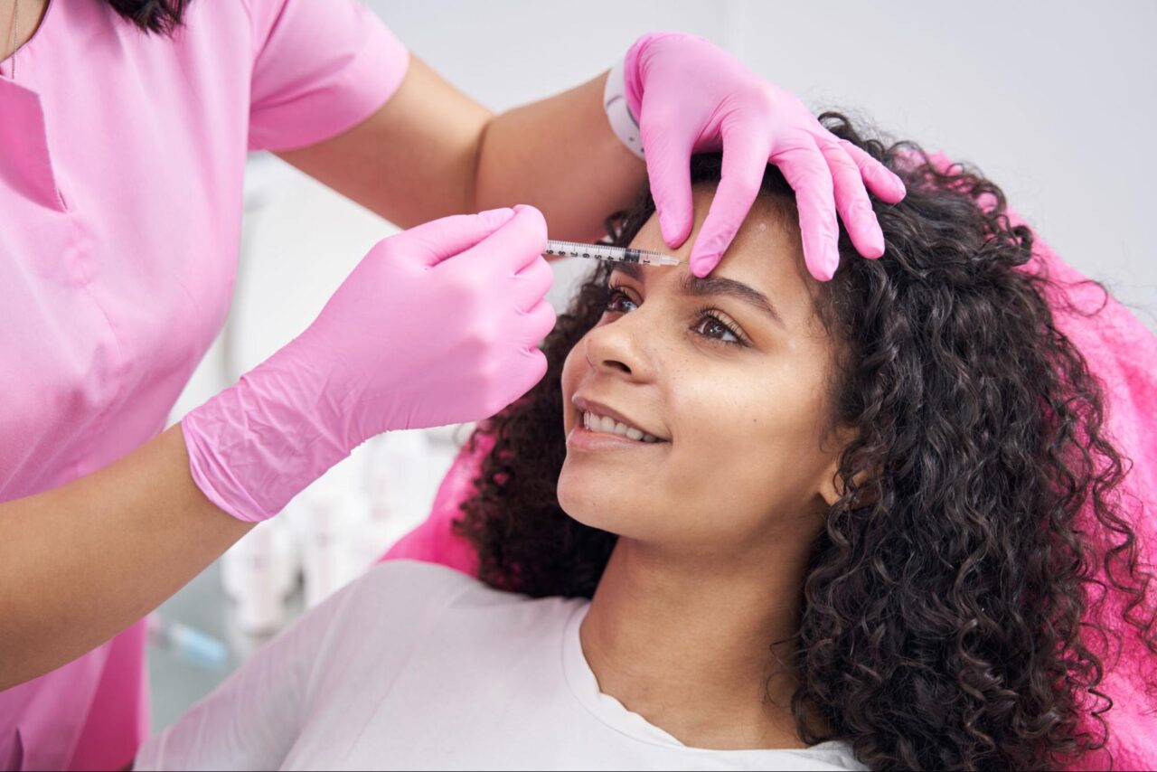 Woman getting Botox injection for forehead lines