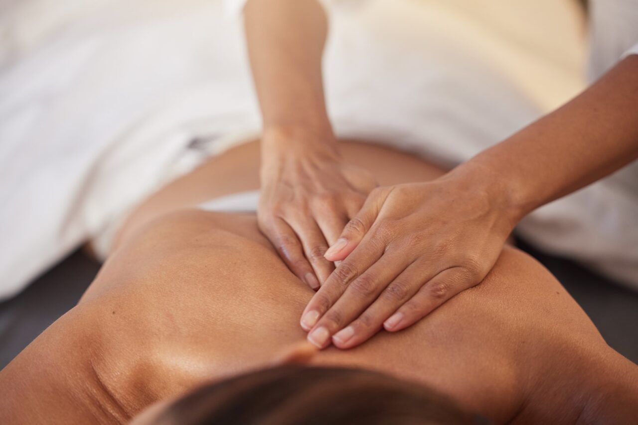 Closeup of massage therapist's hands on patient's back