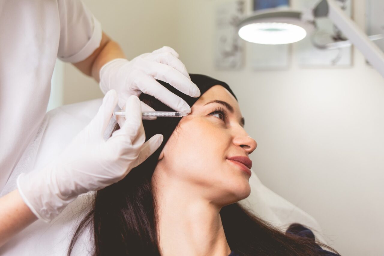Practitioner injecting botox into patient's crow's feet